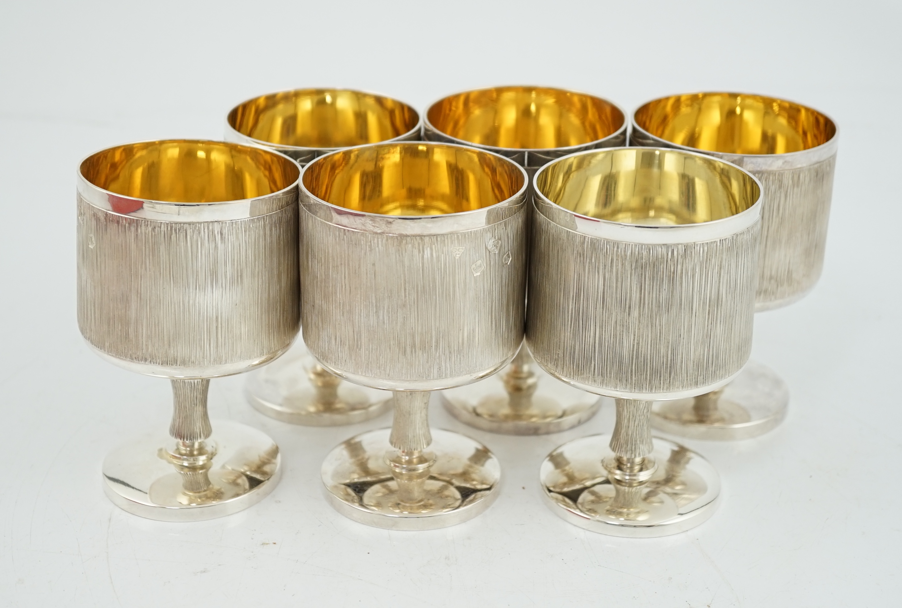 A set of six Elizabeth II textured silver pedestal goblets, by Garrard & Co Ltd